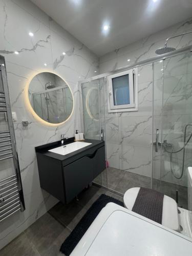 a bathroom with a sink and a shower and a mirror at Pramanta Nest in Pramanta