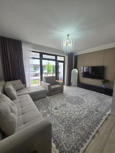 a large living room with a couch and a tv at Baytur Resort таунхаус in Bosteri