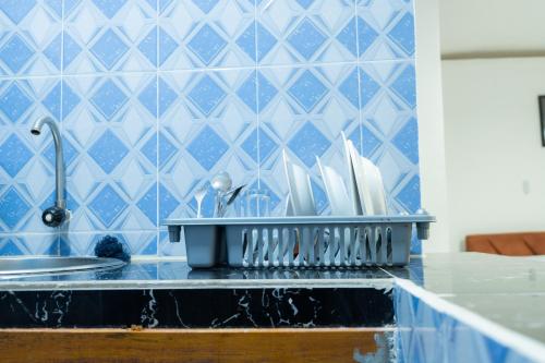 a bathroom with a sink and a blue tiled wall at Residence Singa in Abidjan