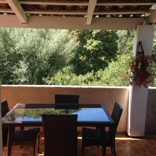 - une table et des chaises sur une terrasse avec vue sur les arbres dans l'établissement Maredda 1, à Sartène