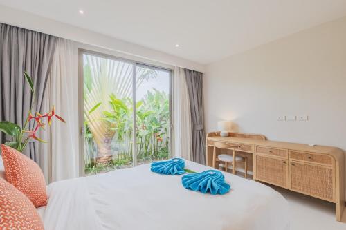 a bedroom with a bed and a desk and a window at Luxury 3-Bedroom private pool villa Trichada Breeze in Phuket