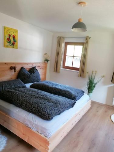 a bedroom with a large bed with blue pillows at Ferienwohnung Mittergutnigg in Innervillgraten