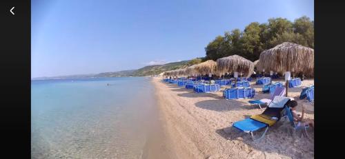 a group of beach chairs and umbrellas on a beach at Casa Patronimio Aristotle Socrates Residence in Ierissos