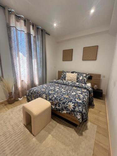 a bedroom with a bed and a chair and curtains at Refuge champêtre in Champagnole