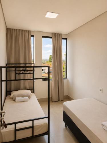 a bedroom with two bunk beds and a window at Vila inn hotel in Brasília