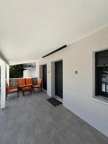 an empty patio with orange chairs and a fireplace at Diktamo Village House in Ofrínion