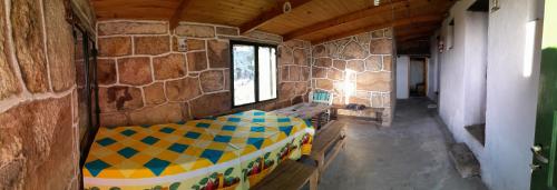 a room with a bed in a stone wall at Rinconcito Serrano in Mina Clavero