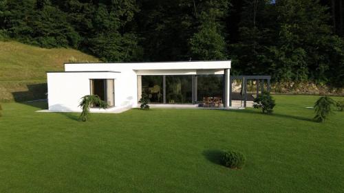 a small white house in a field of grass at Apartma Belvi in Brežice