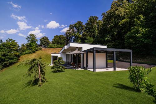 a house on a hill with a green lawn at Apartma Belvi in Brežice