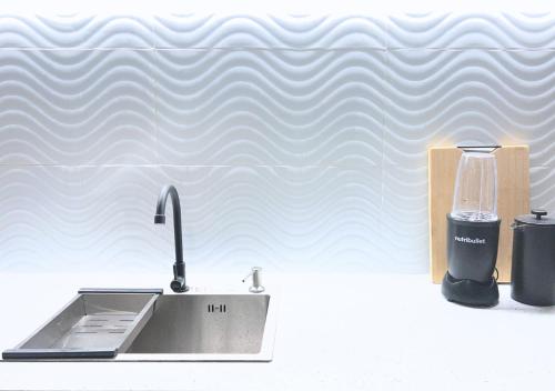 a kitchen sink with a faucet next to a cup at The Retreat in Panglao Island