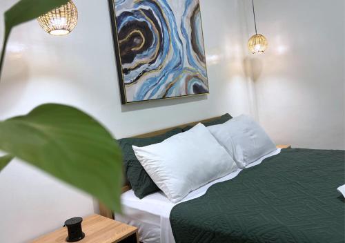 a bedroom with a bed and a painting on the wall at The Retreat in Panglao Island