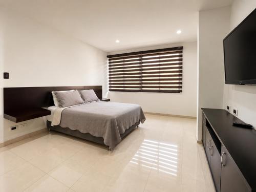 a bedroom with a bed and a flat screen tv at Espectacular, Casa Vacacional Jpol in Cali