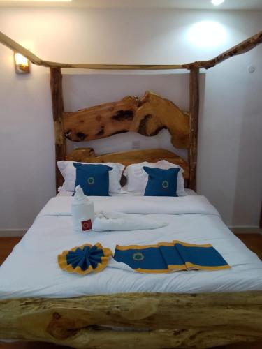 a bed with blue and yellow pillows on it at Goldenview Gardens Elementaita in Gilgil