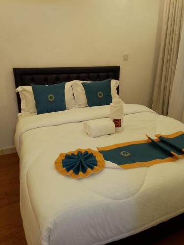 a bed with blue and yellow decorations on it at Goldenview Gardens Elementaita in Gilgil