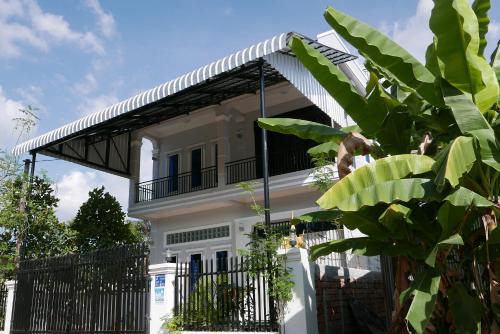 a white house with a black iron fence at Anou Home - Guesthouse in Siem Reap