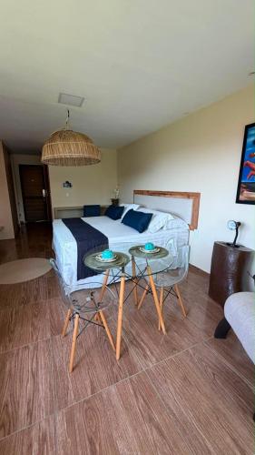 a bedroom with a bed and two tables and a couch at HOTEL IBIZA CUMBUCO in Cumbuco