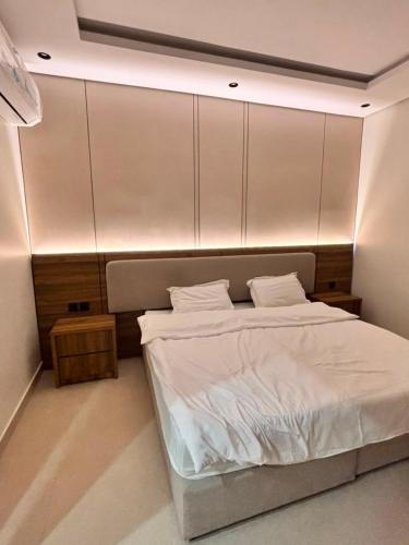 a bedroom with a bed with white sheets at ايراد للشقق المفروشه in Dammam