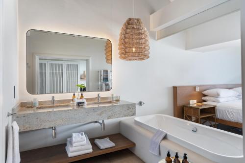a bathroom with a tub and a large mirror at Sala Beach House in Ballito