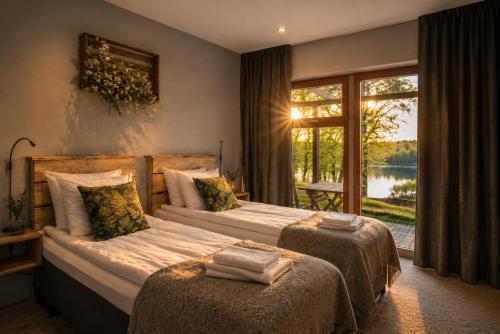 a bedroom with two beds and a large window at Åkulla Outdoor Resort in Rolfstorp