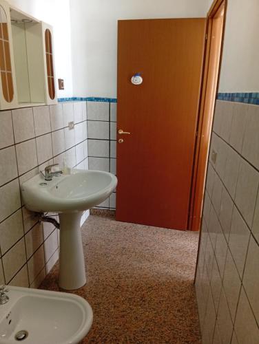 a bathroom with a sink and a brown door at La collinetta in Casa Regnano