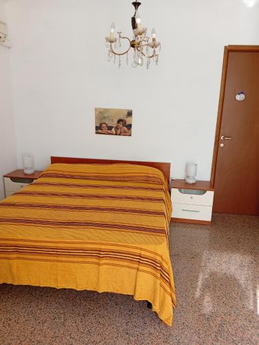 a bedroom with a bed with a yellow blanket on it at La collinetta in Casa Regnano