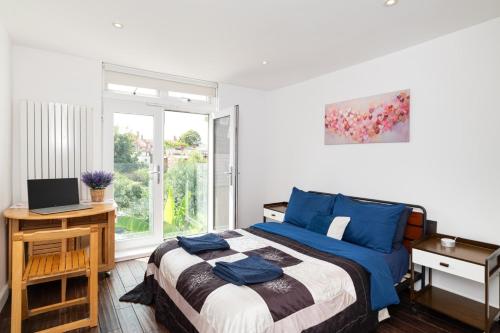 a bedroom with a bed and a desk and a window at Holiday Lets London 4 in London