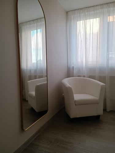 a mirror in a room with a white chair and a chairpect at Svečių namai Lanko g. in Klaipėda