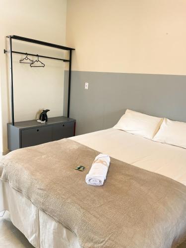 a bed with a towel sitting on top of it at Hospedaria Terra da Opala in Pedro II
