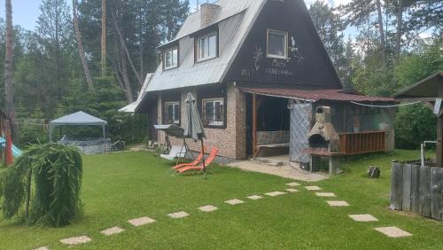 a small house with a yard with a lawn sidx sidx sidx at Chata Strbianka in Tatranska Strba