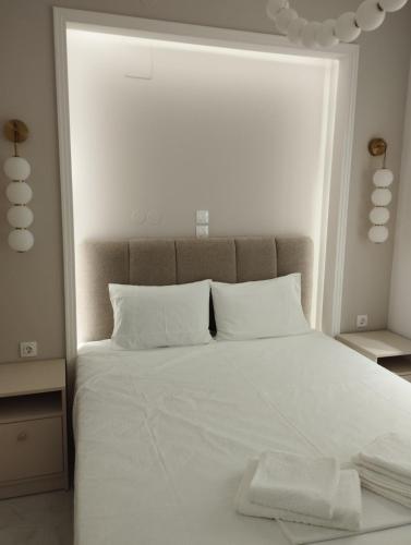 a bedroom with a white bed with a large window at Garden apartment G in Xanthi