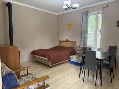 a bedroom with a bed and a table and chairs at Okatse Lodge in Gordi