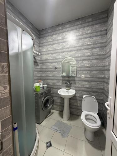 a bathroom with a toilet and a sink at Okatse Lodge in Gordi