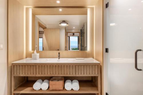 a bathroom with a sink and a mirror at Hilton Club Ka Haku Honolulu in Honolulu