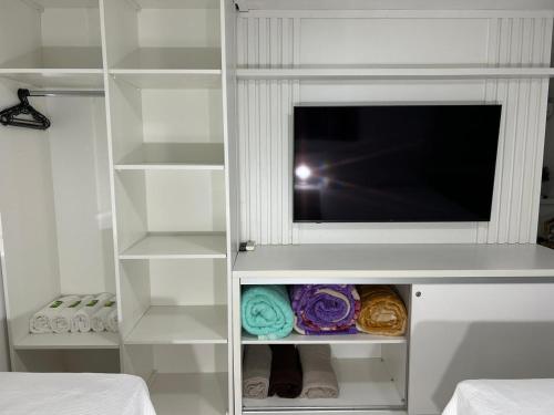 a white book shelf with a flat screen tv at San Clemente Residence in Gramado