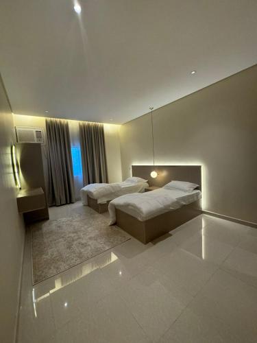 a bedroom with two beds and a window at فندق ارض الراحة in Khamis Mushayt