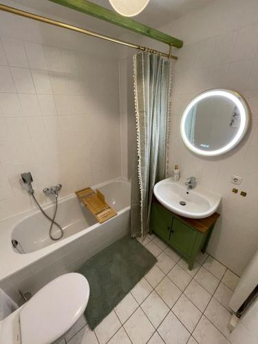 a bathroom with a toilet and a sink and a tub at Panoramablick am Theaterplatz stilvolle Wohnung in Chemnitz
