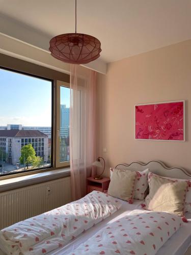 a bedroom with a bed and a large window at Panoramablick am Theaterplatz stilvolle Wohnung in Chemnitz