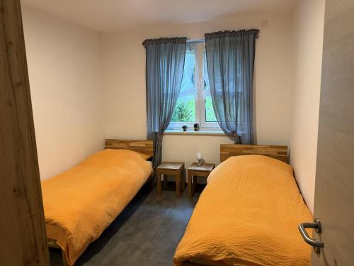 two beds in a small room with a window at Ferienwohnung26 in Blankenfelde