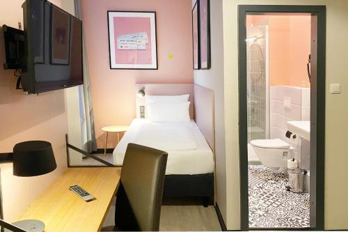 a small room with a bed and a bathroom at Garner Hotel Hamburg St. Georg by IHG in Hamburg