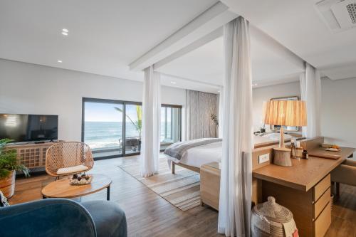 a hotel room with a bedroom with a bed and a desk at Sala Beach House in Ballito