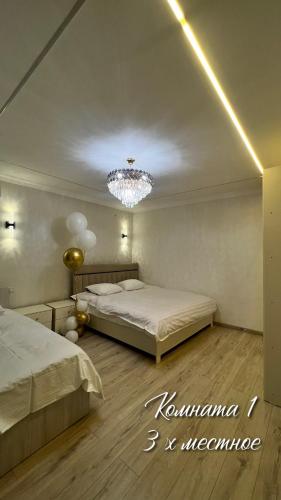 a bedroom with two beds and a chandelier at Royal hostel in Osh