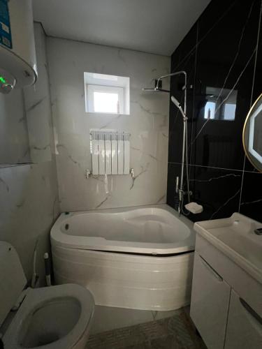 a bathroom with a tub and a toilet and a sink at Royal hostel in Osh