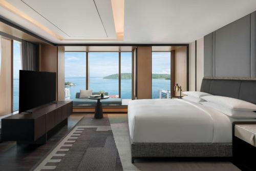 a bedroom with a large bed and a large window at Sheraton Kota Kinabalu in Kota Kinabalu