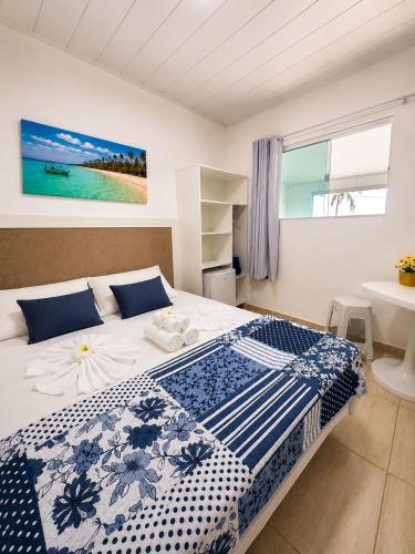 a bedroom with a blue and white bed and a window at Pousada Maragobeach Suits in Maragogi