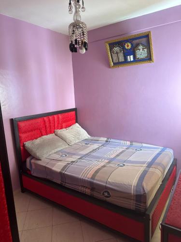 a bed in a room with a purple wall at Appartement Pour Vacances in Agadir