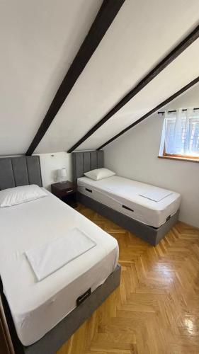 a bedroom with two beds in a attic at Apartmani Kovačević in Kotor