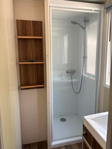 a bathroom with a shower with a glass door at Mobile-home in Ivry-la-Bataille