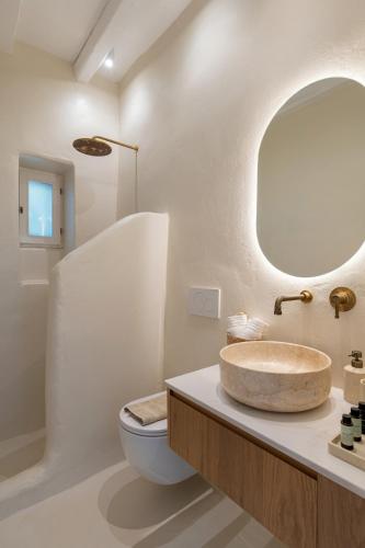 a bathroom with a sink and a toilet and a mirror at Casa Elia in Sarakíniko