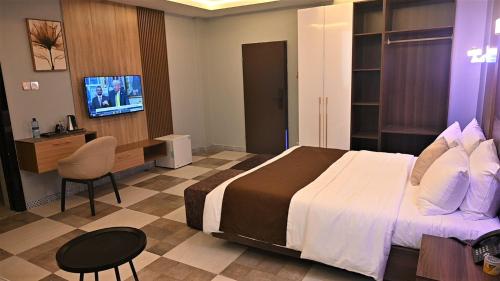 a hotel room with a bed and a flat screen tv at Andysilk Resort International in Ozu Abam