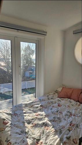 a bedroom with a bed and a large window at Gäststugan in Åkersberga